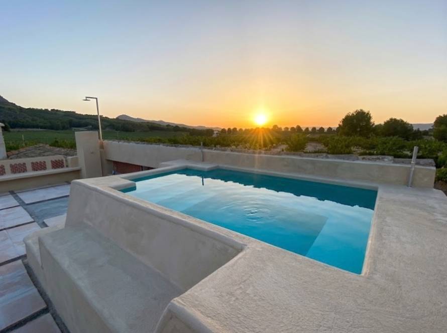 Piscina de poliéster instalada en una parcela al atardecer