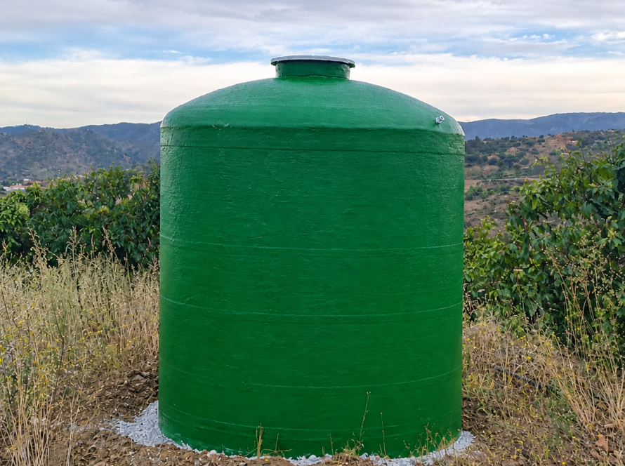 Depósito de poliéster vertical de color verde instalado en una finca